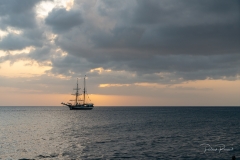 Coucher de soleil derrière une goelette classique mouillée à Rivière-Sens