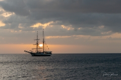 Coucher de soleil derrière une goelette classique mouillée à Rivière-Sens
