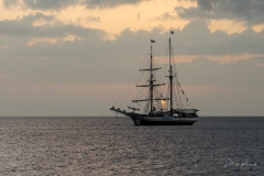 Coucher de soleil derrière une goelette classique mouillée à Rivière-Sens