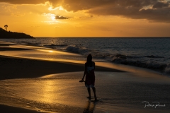 La jeune femme au coucher de soleil sur la plage de la Perle